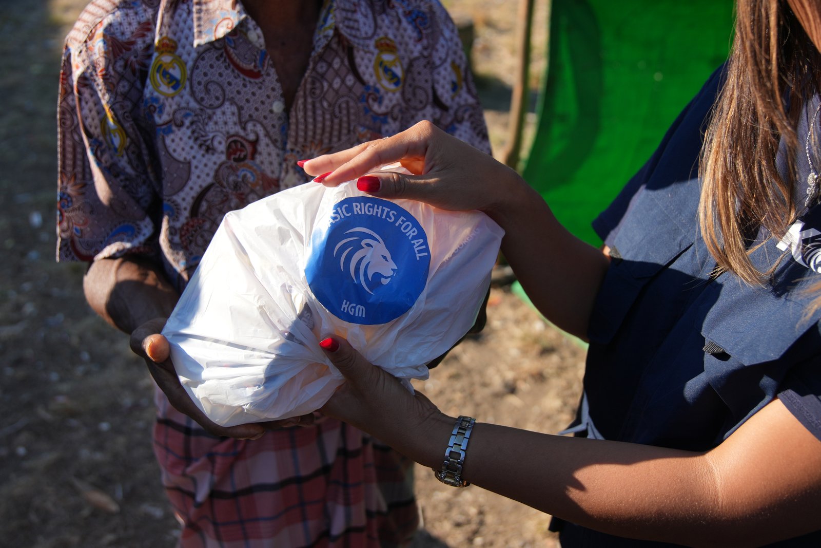 A supply bag marked Basic rights for all passed hand to hand